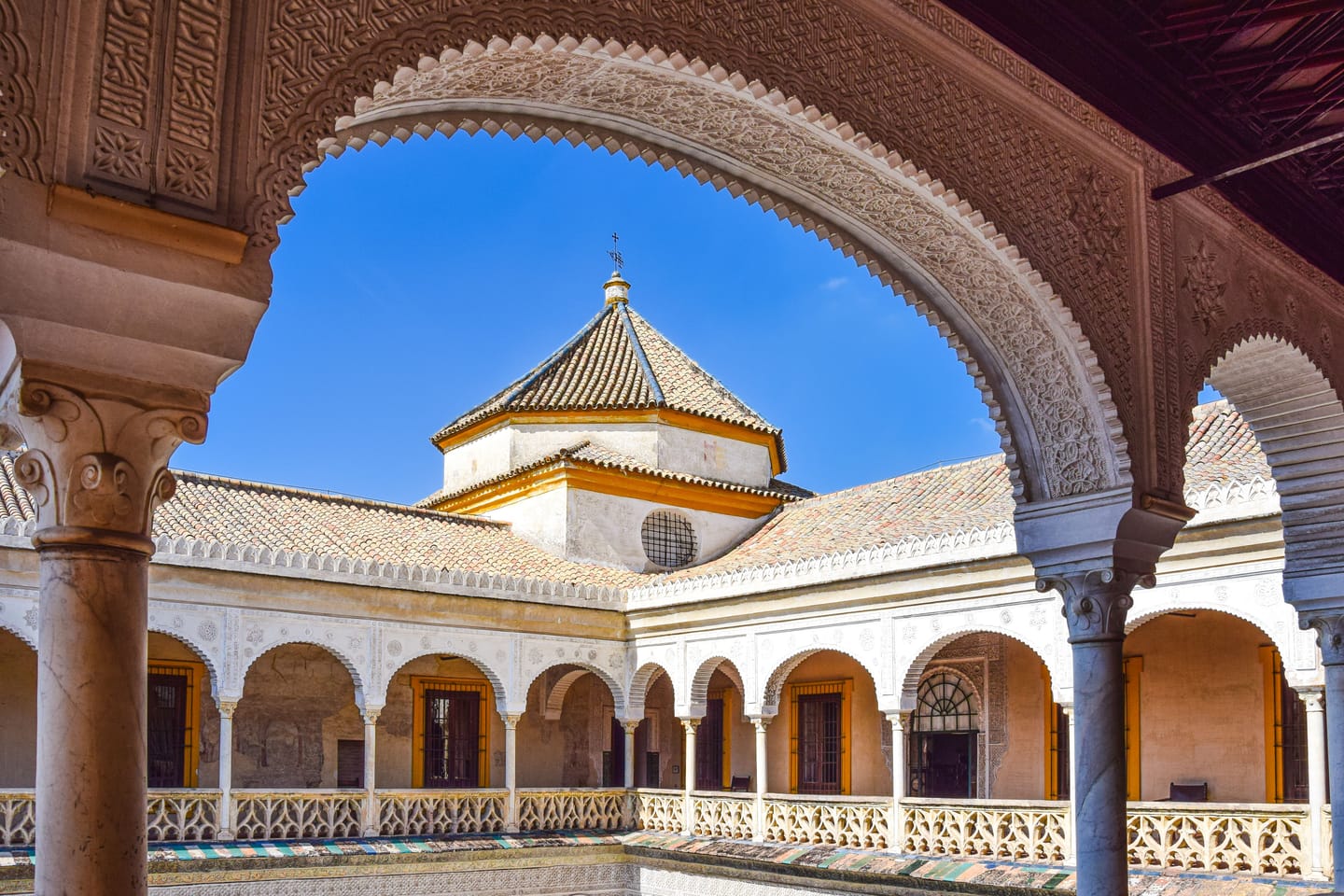 Patio fleuri de Séville, azulejos et arcades.
