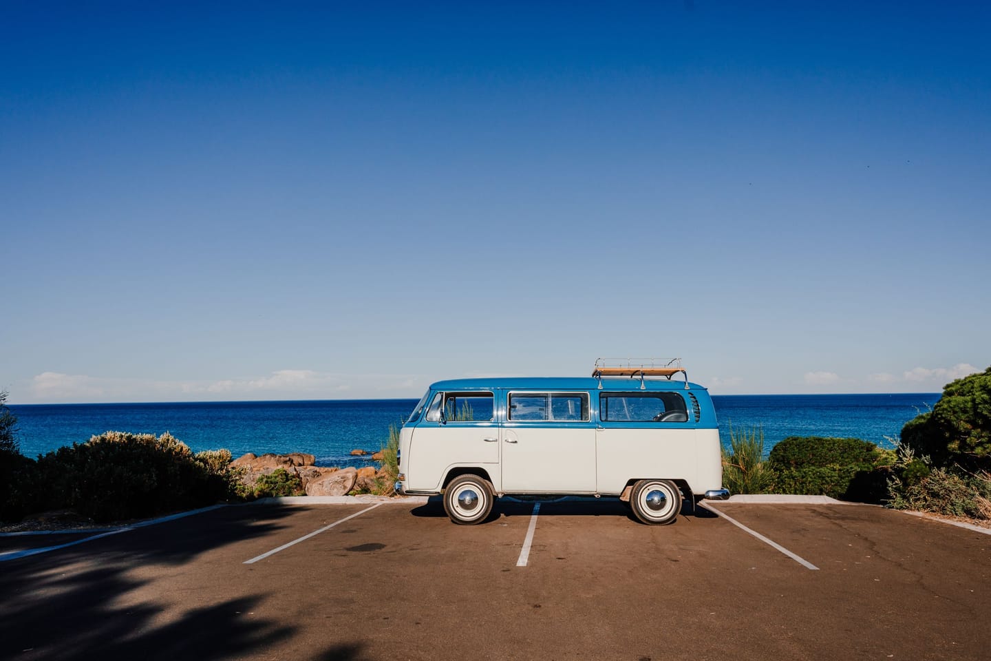 Van on a coastal road at sunset.