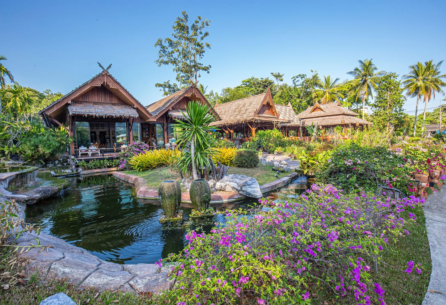The bungalows of an Asian resort in a tropical garden.