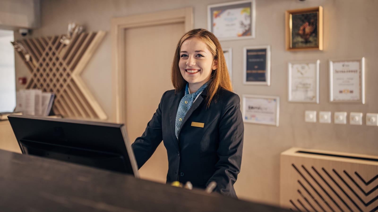 A young professional in hotel uniform on a terrace at first light.