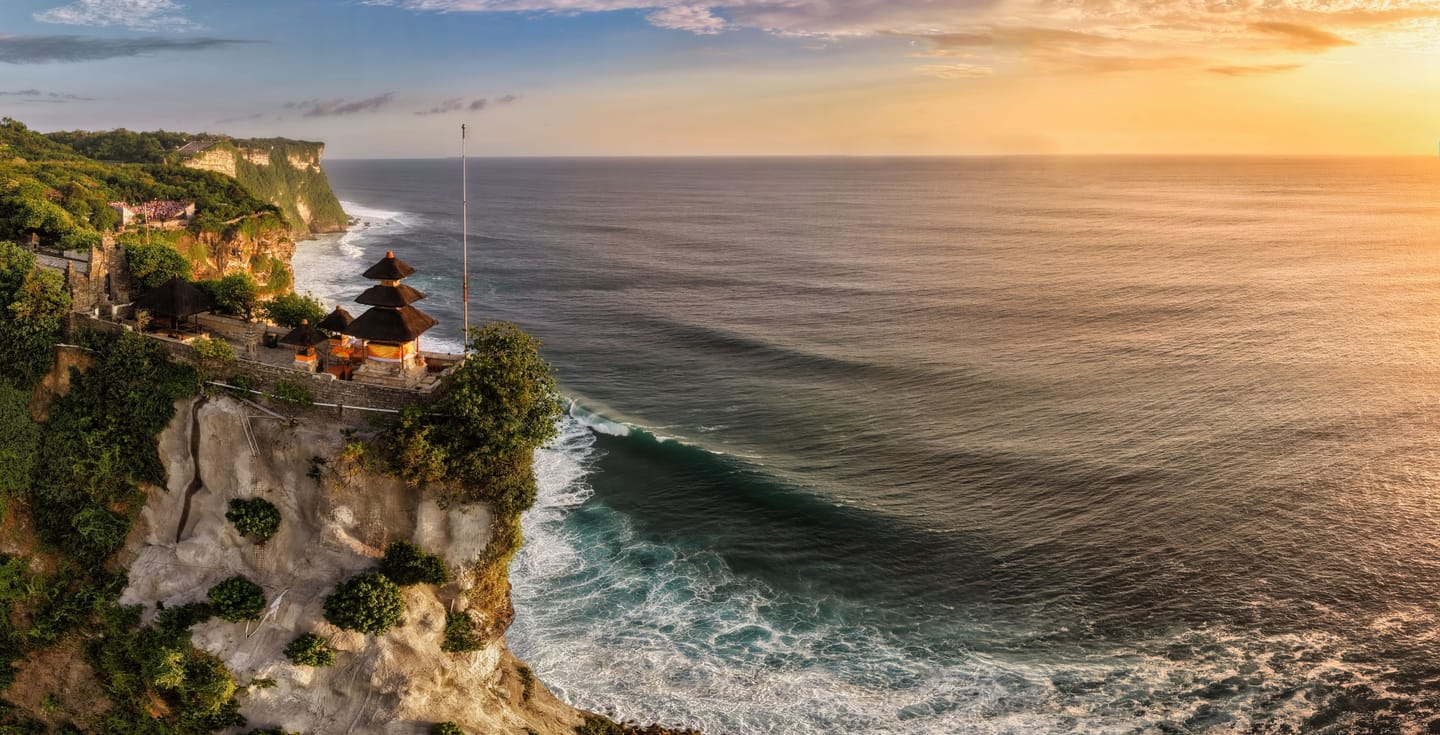 Uluwatu temple at sunset, cliff above the ocean.
