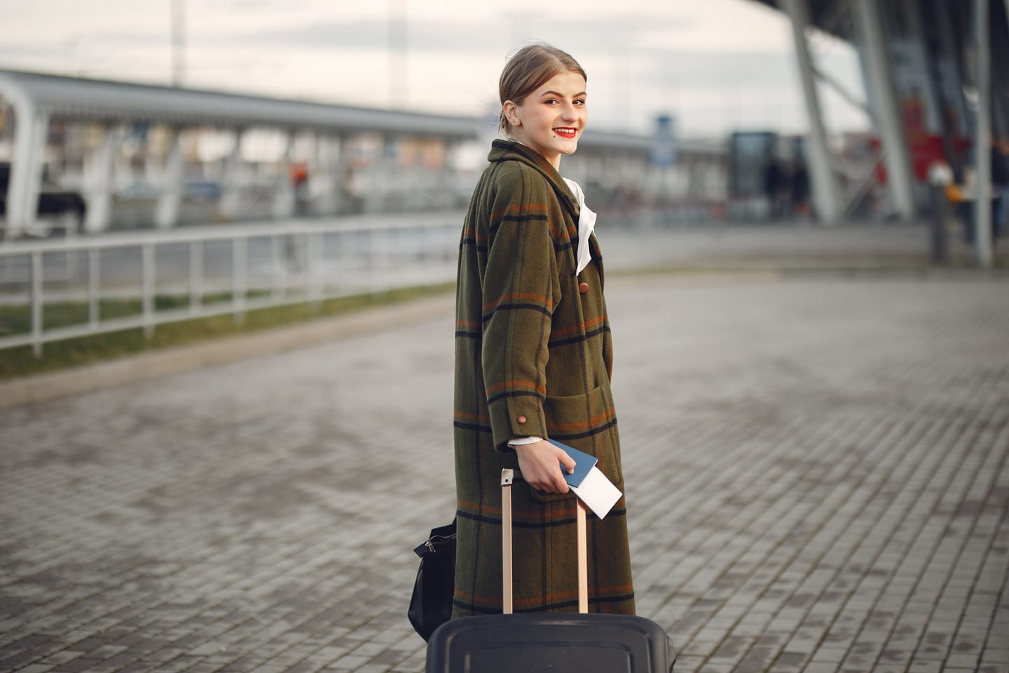 Une jeune femme et sa valise, prête à partir.