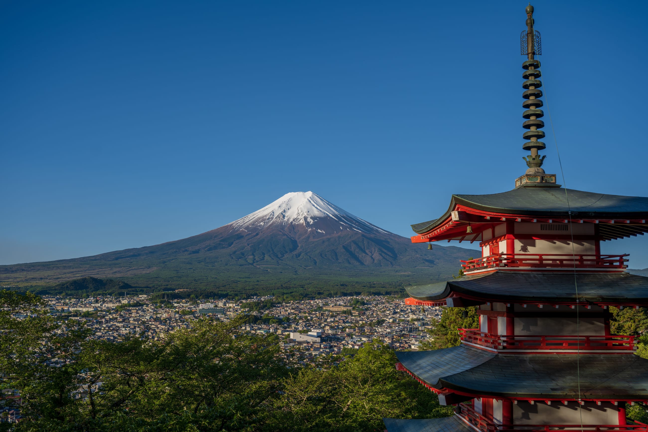 Le mont Fuji au lever du jour derrière un torii vermillon.
