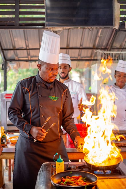 Un chef au flambage, en cuisine.