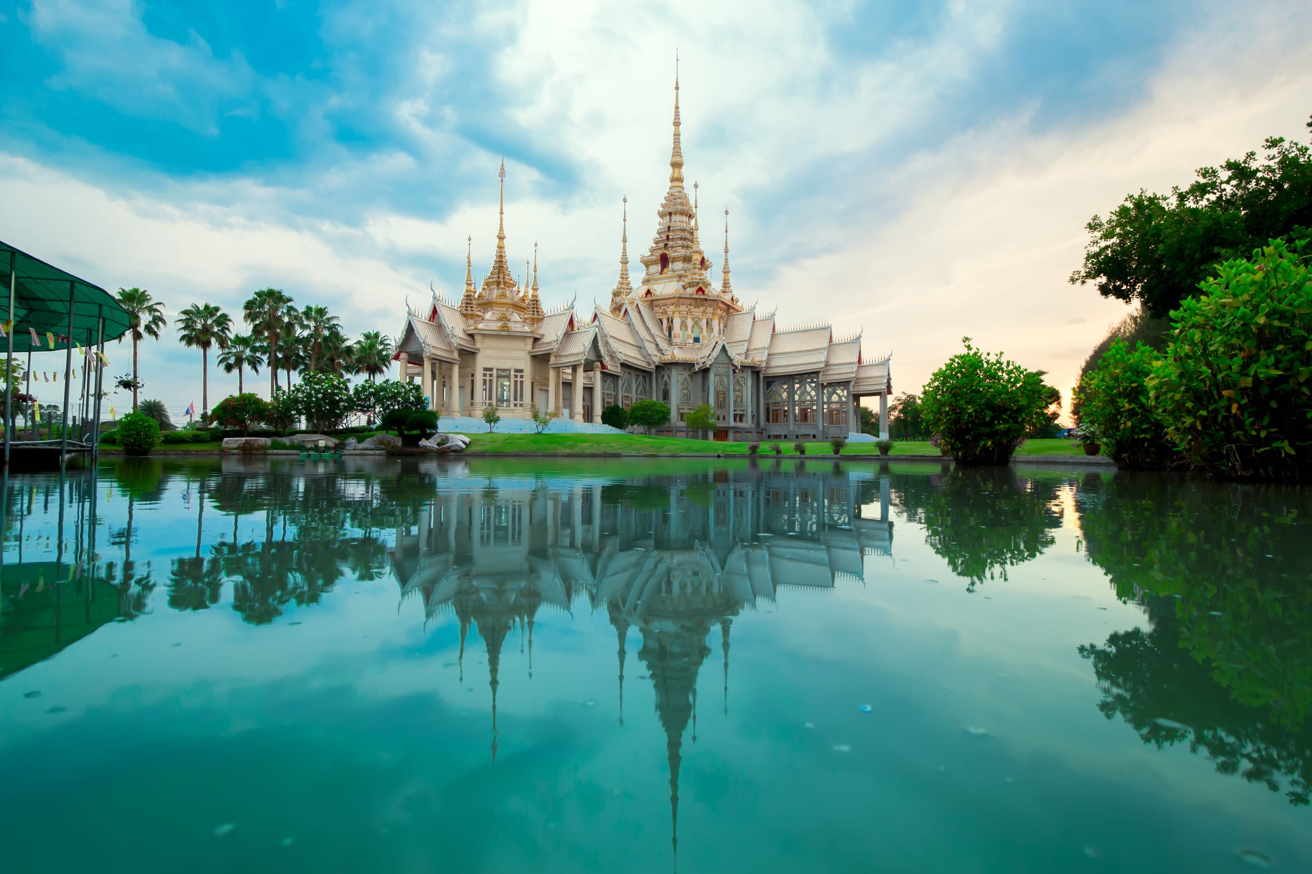 Les temples dorés de Bangkok au crépuscule, au bord du fleuve.