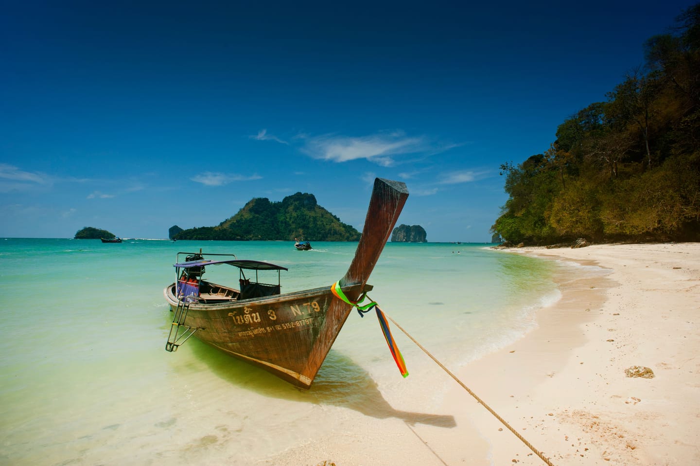 Un bateau longtail entre les pitons calcaires de la baie de Phang Nga.