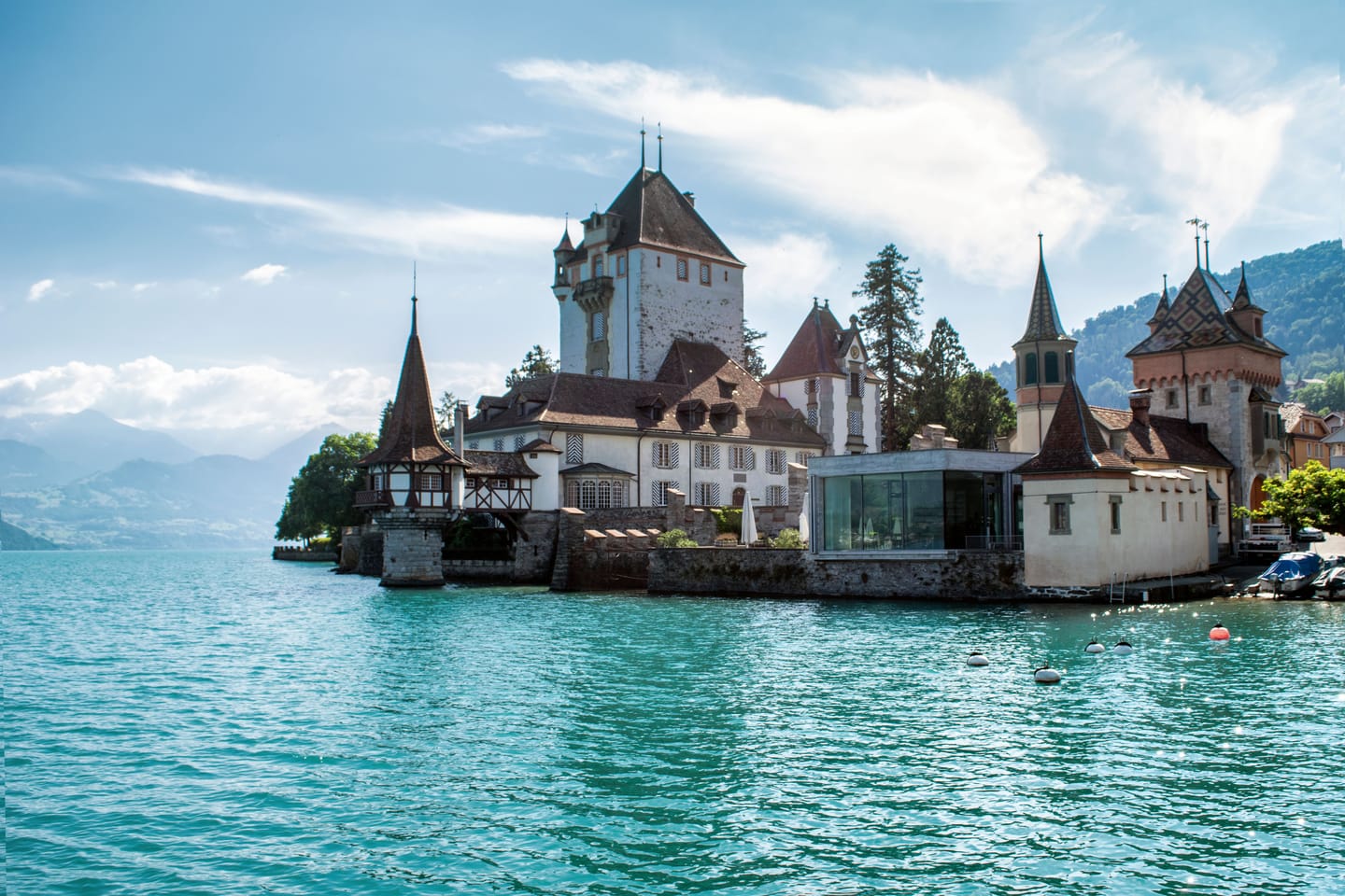 Oberhofen castle standing in the turquoise water of Lake Thun.